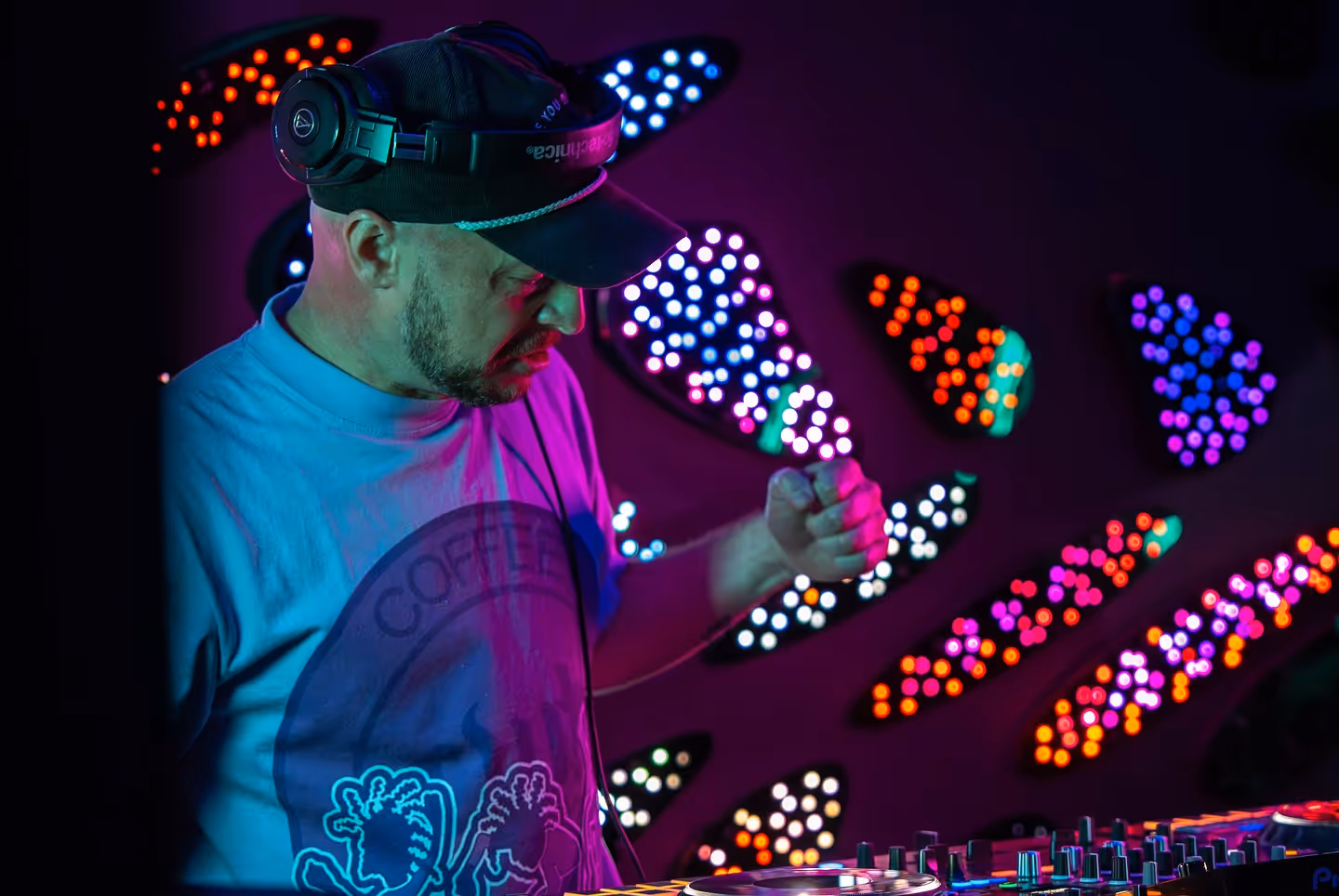 ATL Sync DJ mixing techno under vivid lights