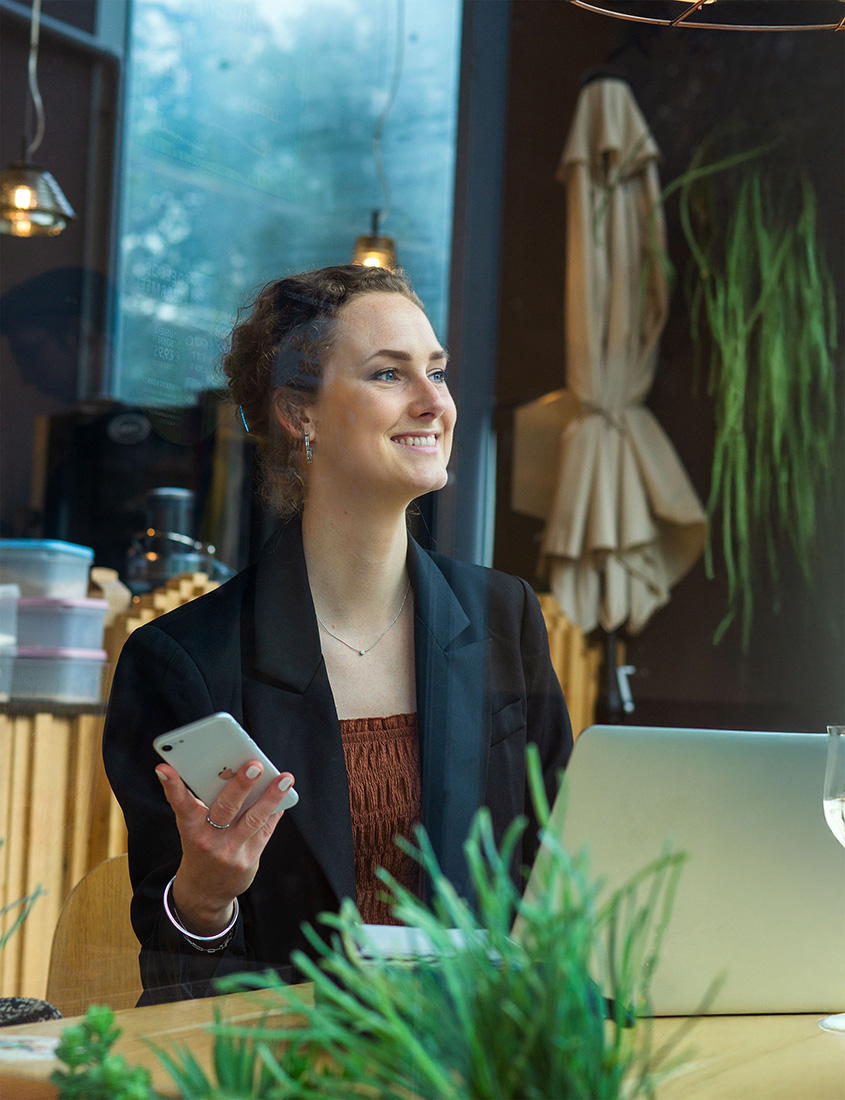 Emily aan het werk achter laptop in koffietent