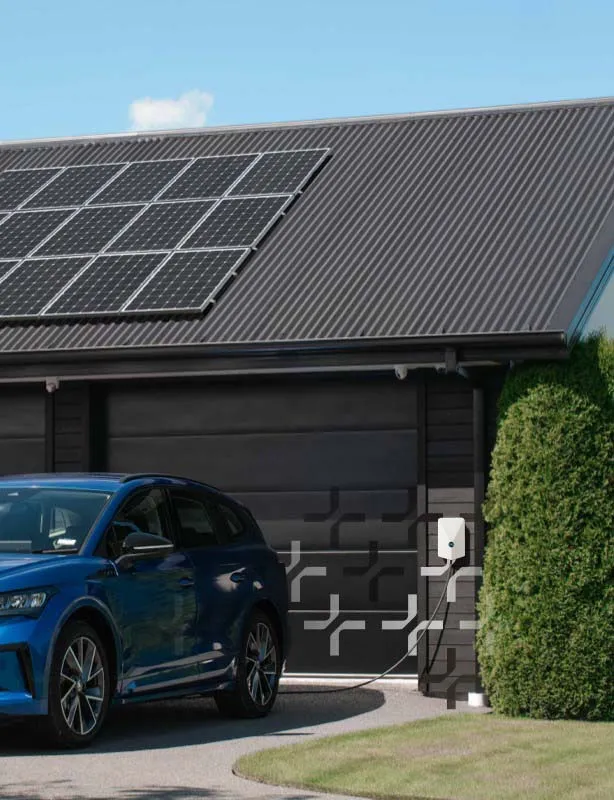 Blue electric car charging outside a house with solar panels on the roof.