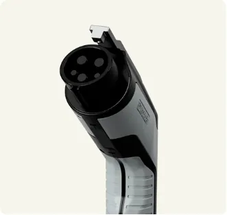 Close-up of a type 1 electric vehicle charging plug with five circular connectors on a grey and black handle.