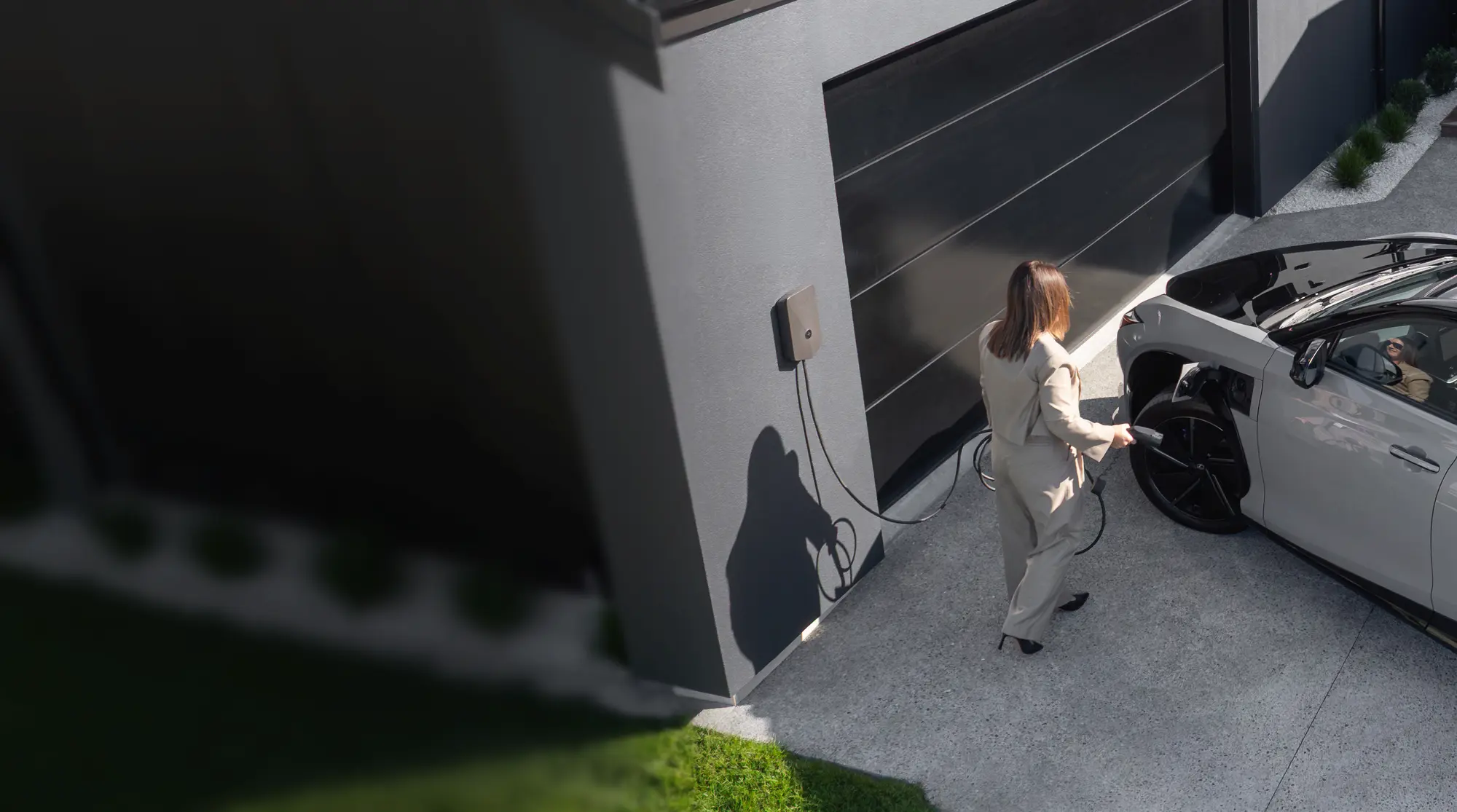 A lady charges her electrified Lexus using an Evnex EV charger