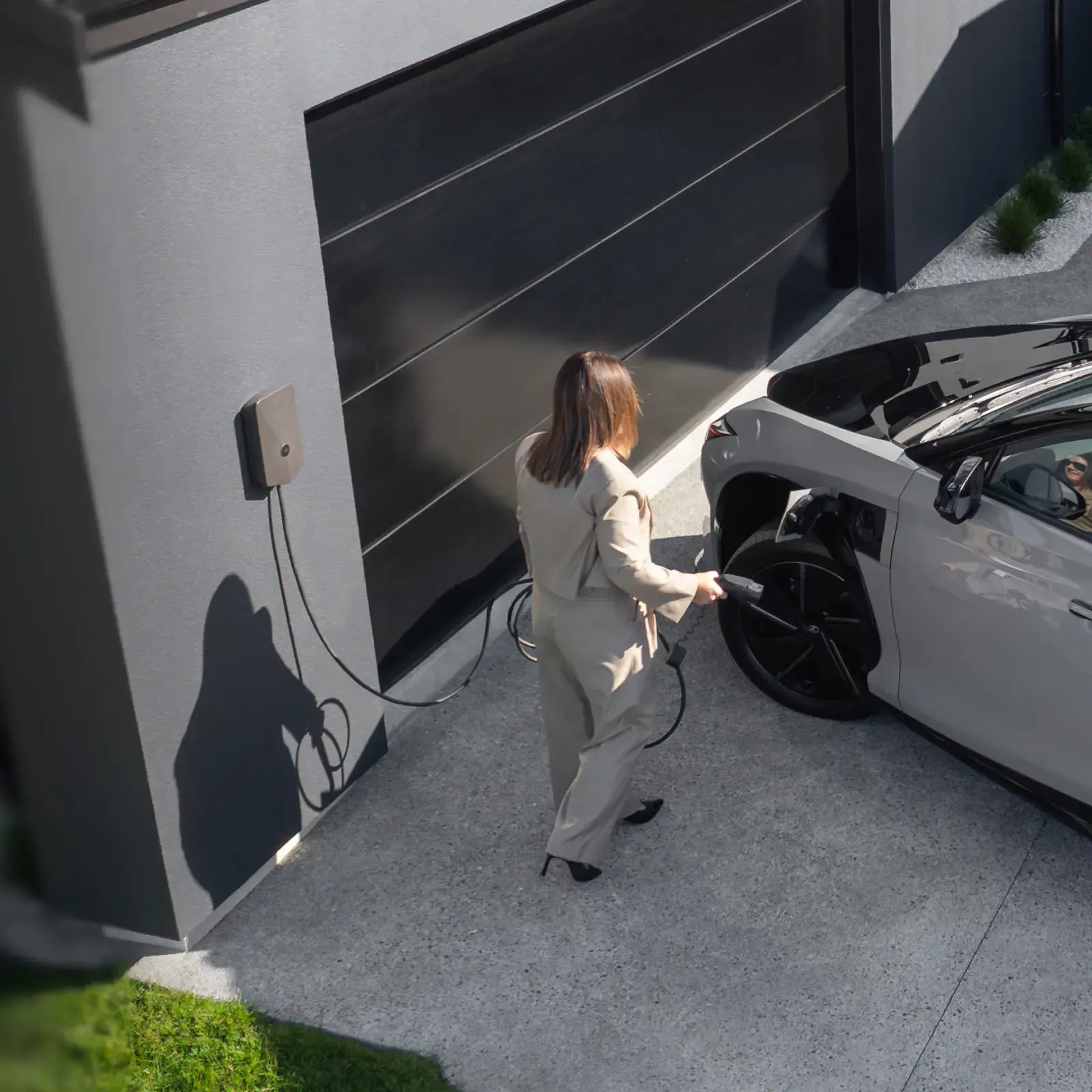 A lady chargers her electrified Lexus using an Evnex EV charger