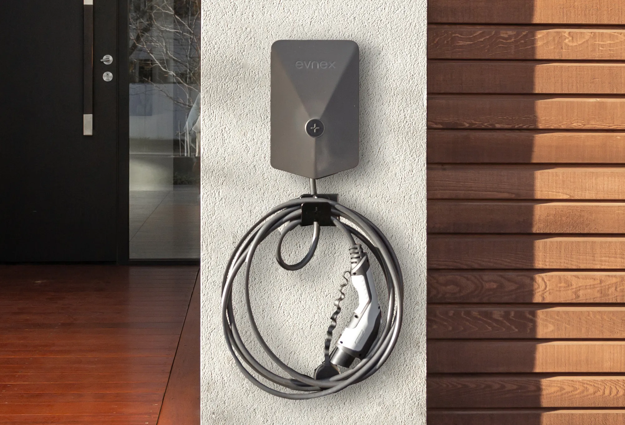 Evnex E2 smart EV chager wall mounted to a home exterior