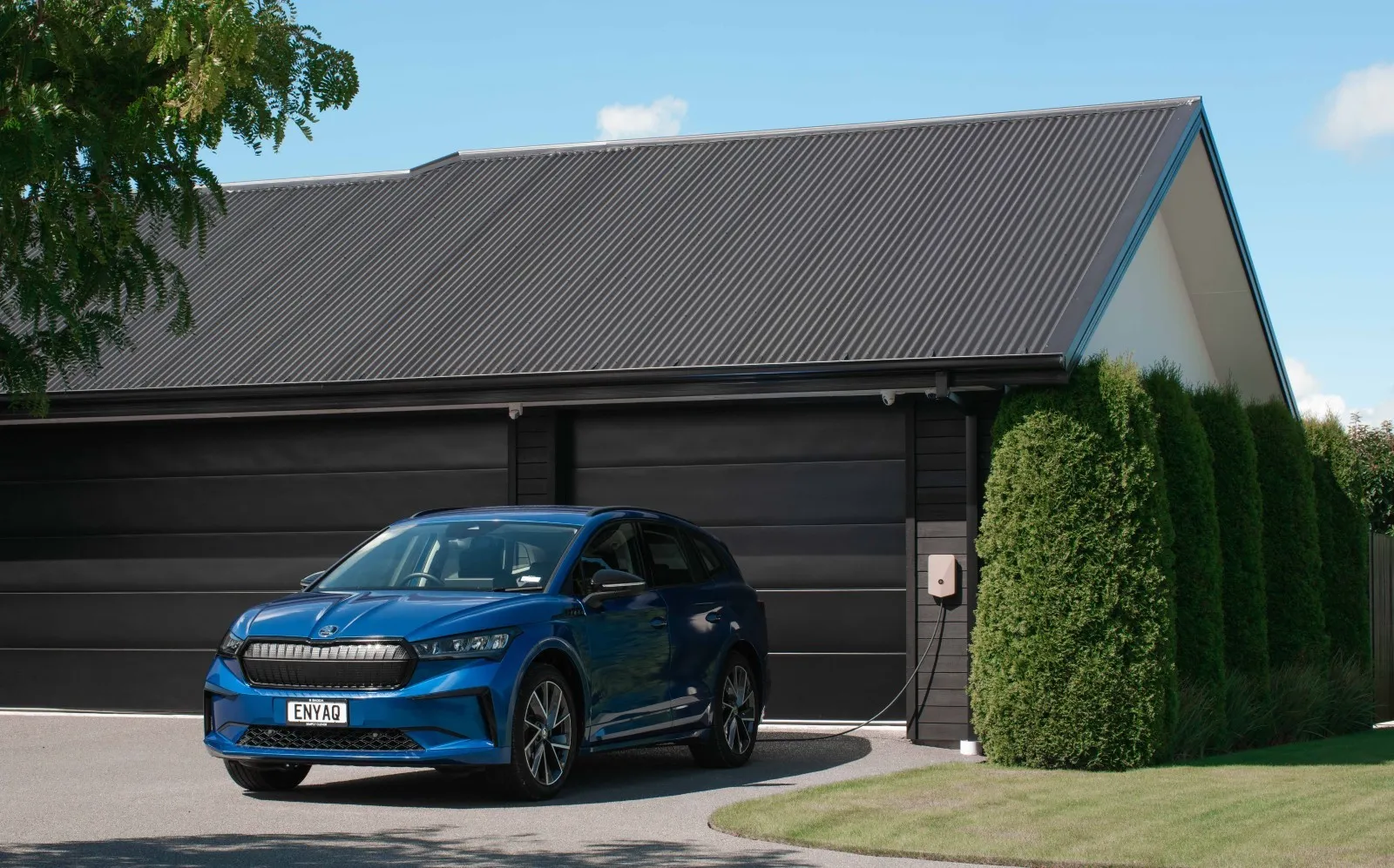 A sand coloured Evnex E2 installed outside a home's garage.