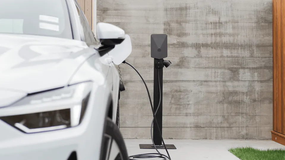 A white Polestar 2 is being charged by an Evnex charger