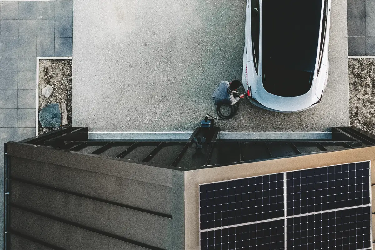 person charging an EV with solar panels