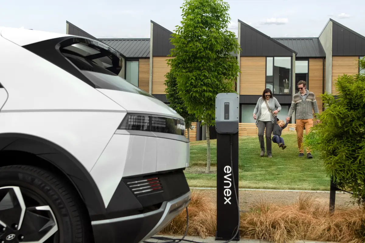 family walking towards charging EV