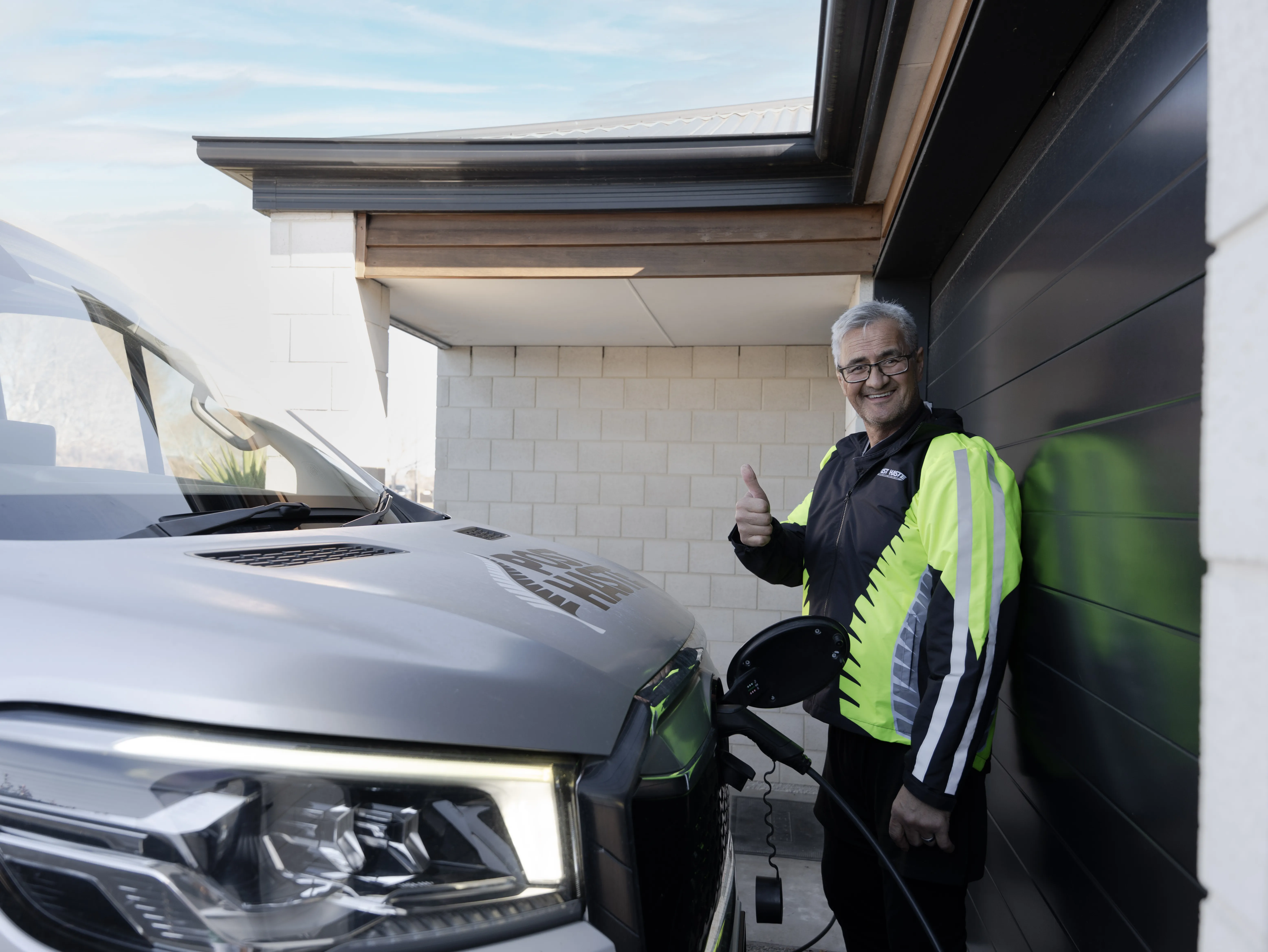 Courier driver charging EV van