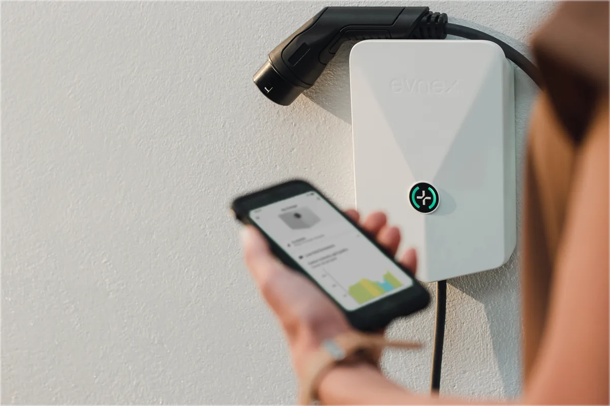 Evnex E2 Plus EV charger in Snow with person holding Evnex app