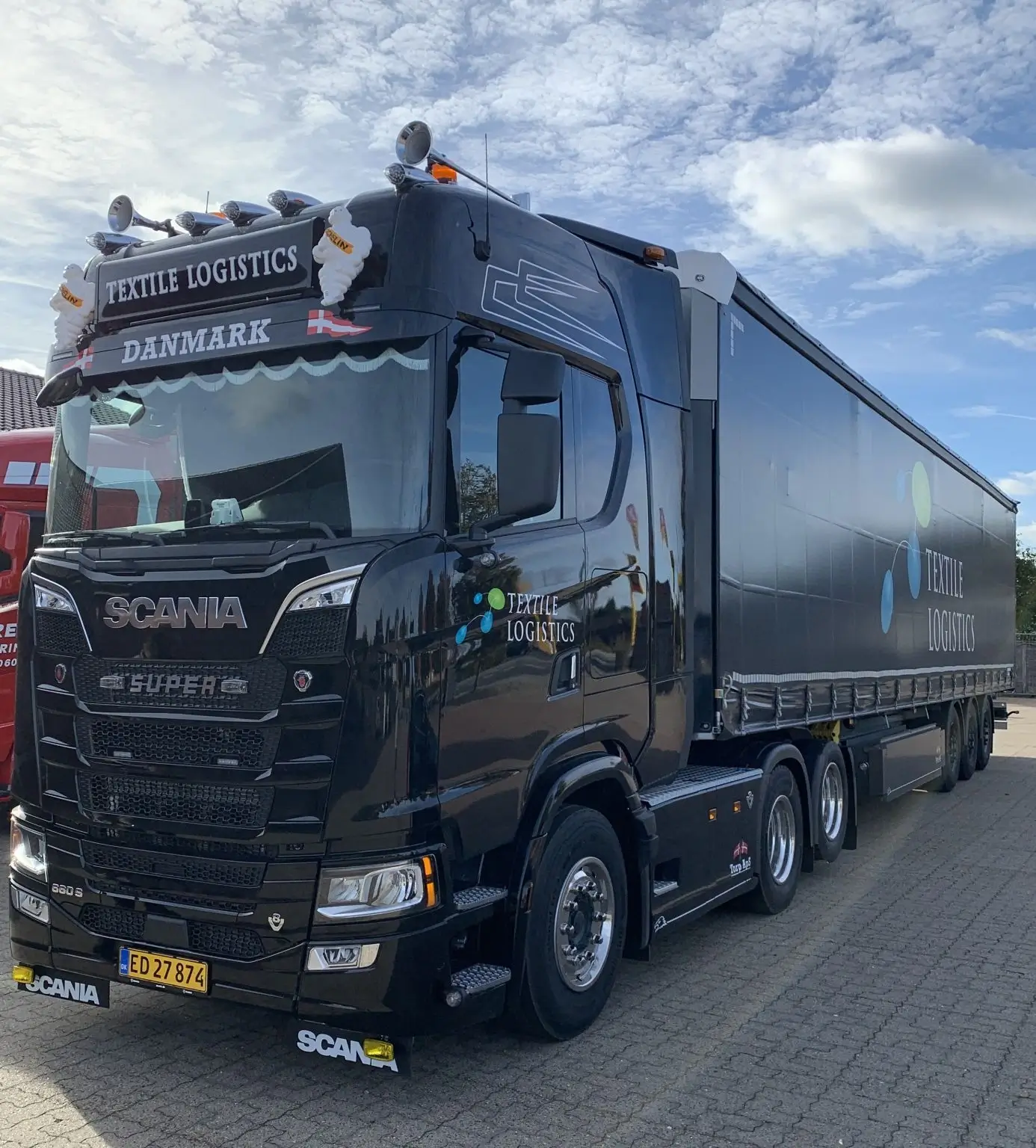 Lastbil fra Textile Logistics holder på parkeringsplads