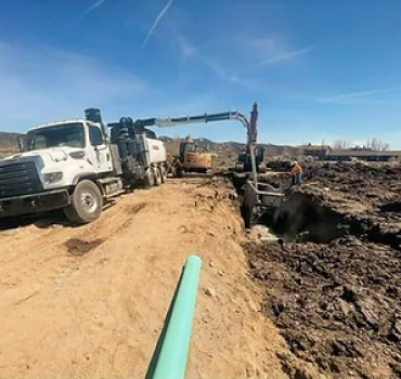 A truck of Pacific West Construction on a dirt road carrying out work.