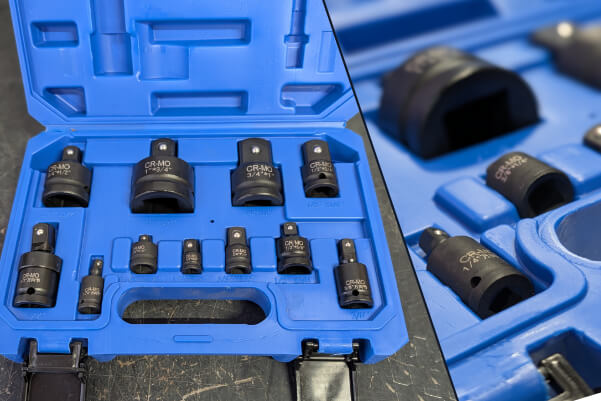 Red and black BOSS Power Start 12/24V jump starter with handle, placed on a reflective surface with a blue gradient background and concrete blocks behind it.