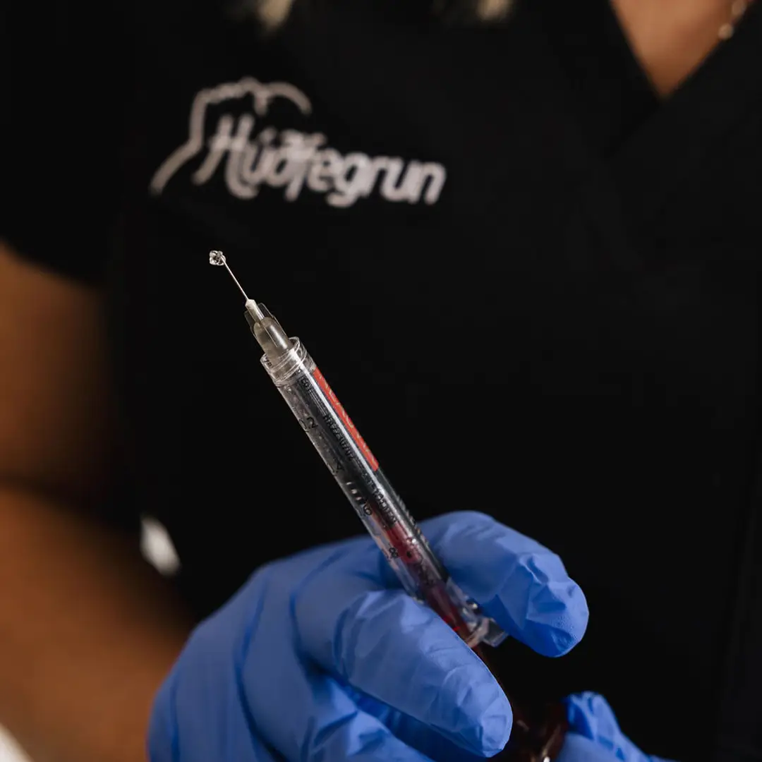 Hjúkrunarfræðingur hjá Húðfegrun sýnir sprautu notaða við gelísprautun. Meðferðin fyllir varir og dregur úr línum og hrukkum á öruggan og náttúrulegan hátt. Bókaðu faglega meðferð í dag.