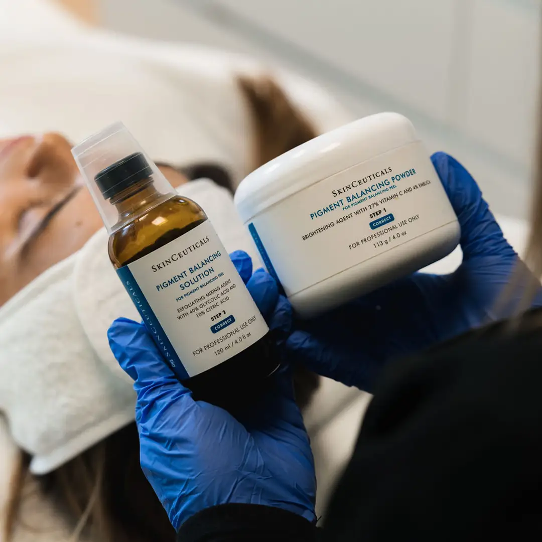 Hjúkrunarfræðingur hjá Húðfegrun sýnir efni notuð í ávaxtasýrumeðferð sem styður árangur lasermeðferðar. Meðferðin endurnýjar húðina og jafnar húðlit. Fullkomið viðbót – bókaðu tíma hjá sérfræðingum.