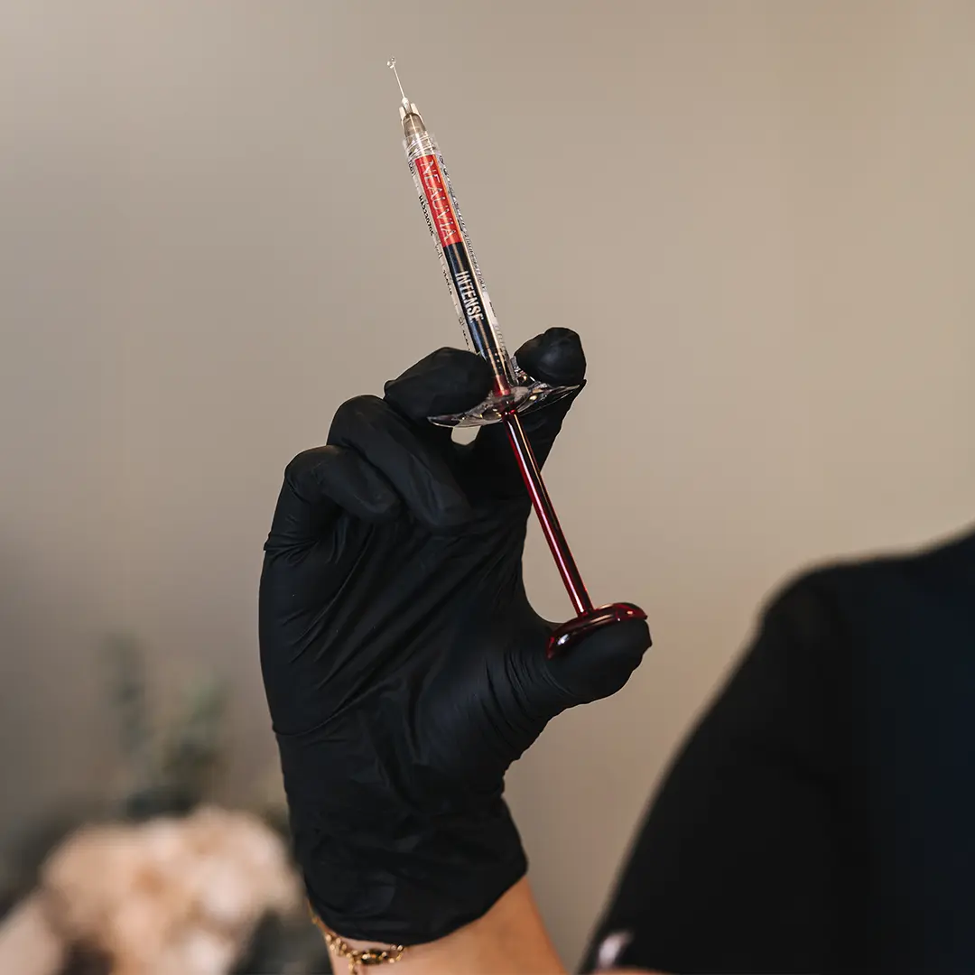 Nærmynd af sprautu með hyaluronic acid booster haldið af vottaðri hjúkrunarfræðingi hjá Hudfegrun. Myndin sýnir meðferðartækið sem notað er til að örva kollagenframleiðslu á öruggan og faglegan hátt í hreinum og nútímalegum aðstæðum kliníkurinnar.