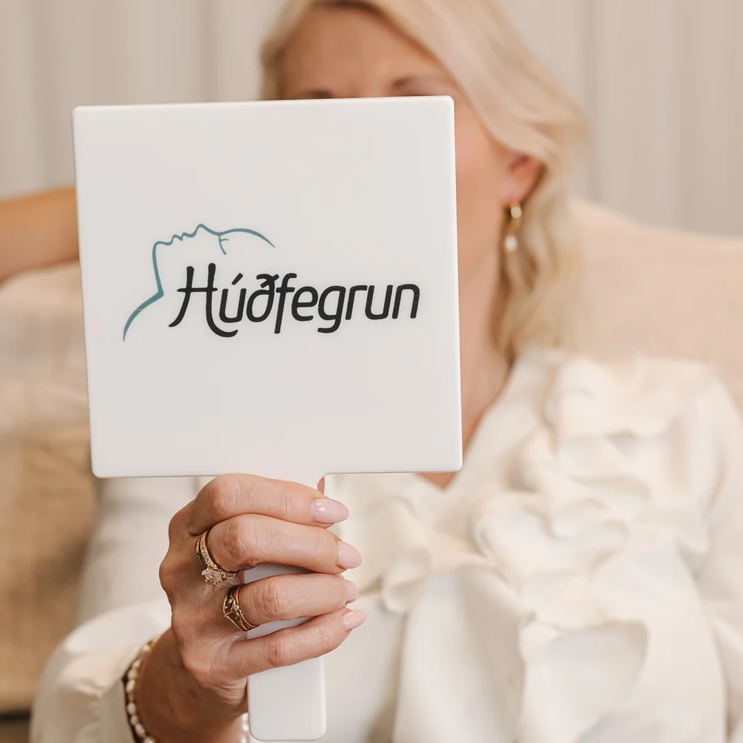 Viðskiptavinur hjá Húðfegrun skoðar meðferðarsvæði fyrir fitueyðingu og líkamsmótun