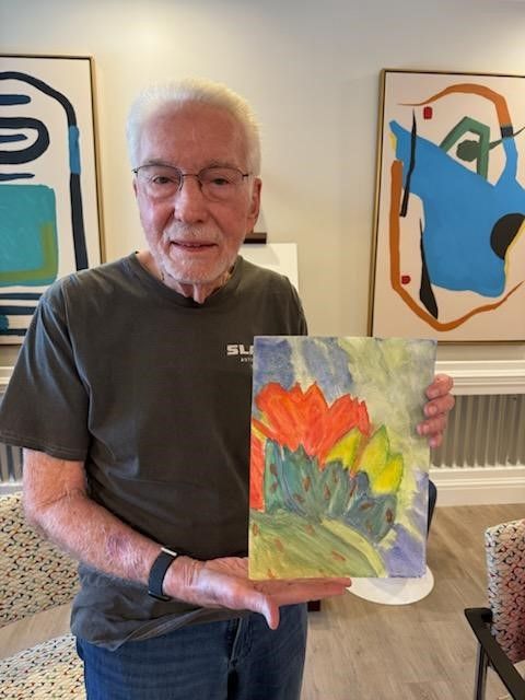 A participant shows his flower painting from a JFCS Arizona art class