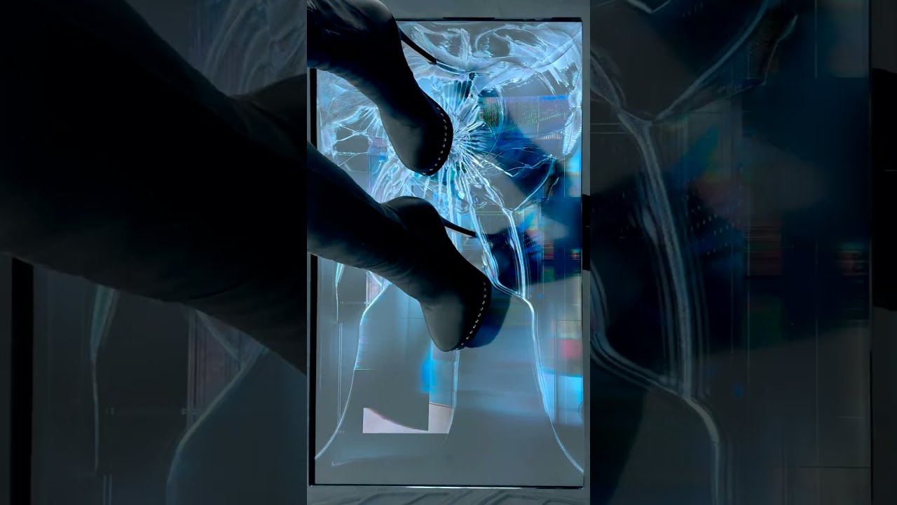 Woman beside a mirror in a monochrome fashion video still