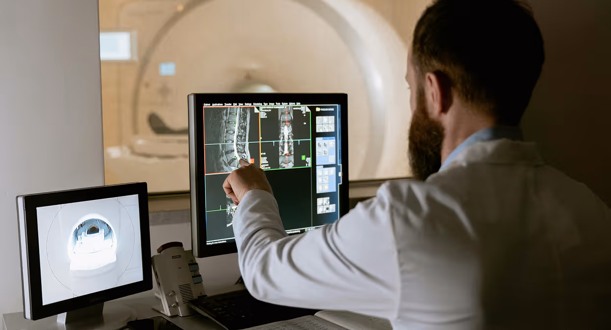 Radiologist reviewing detailed medical imaging scans on a computer screen.