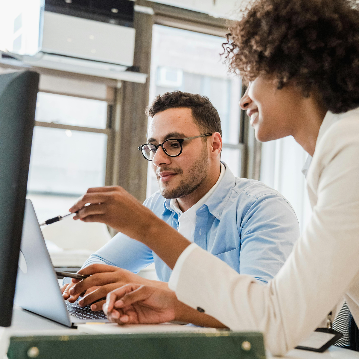 Two startup team members collaborating on AI feature development using healthcare data