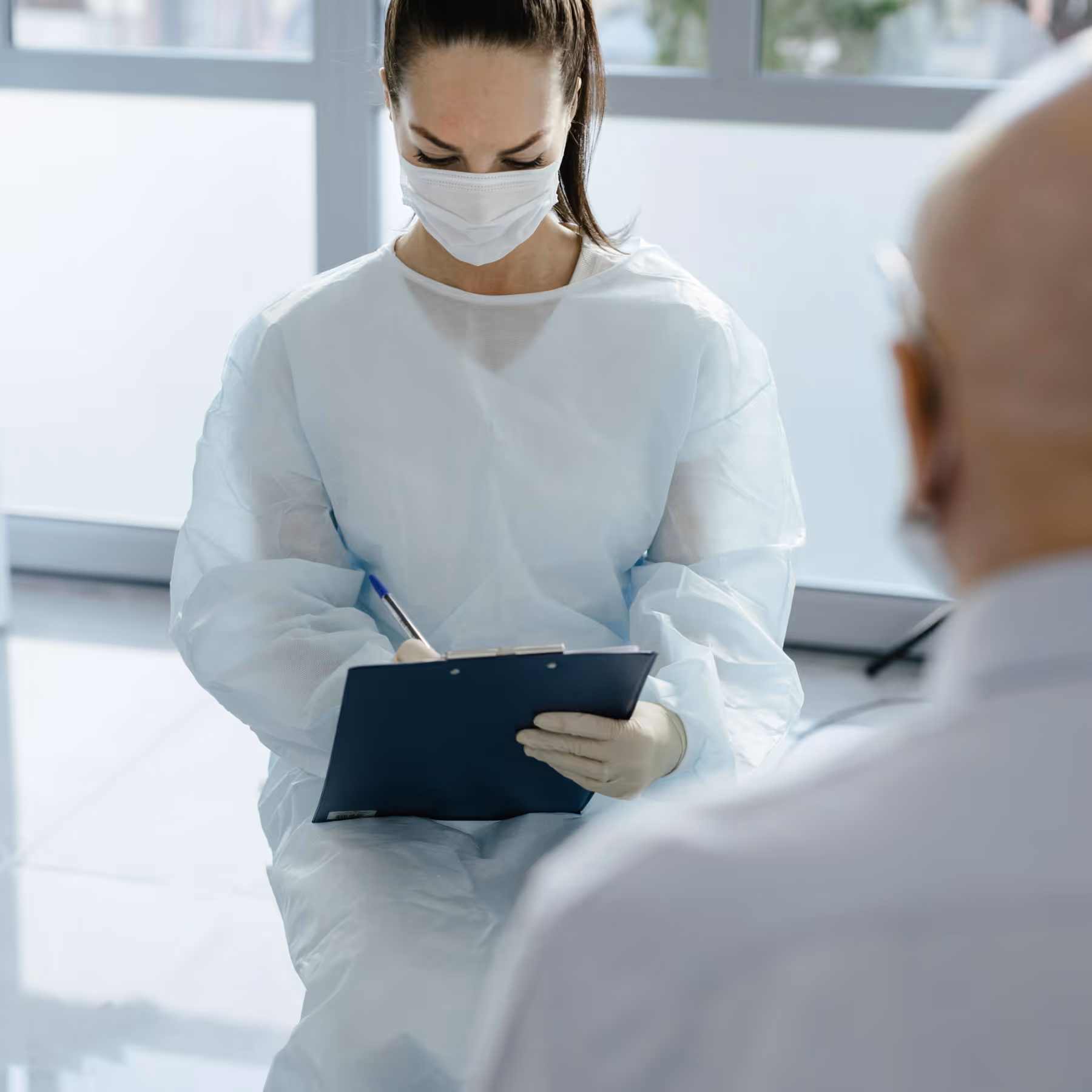 a healthcare professional during a patient consult, filling their health data in the files
