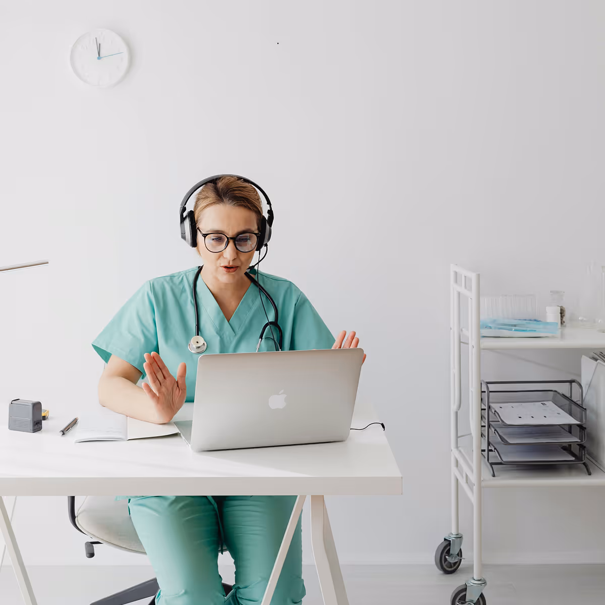 Healthcare professional conducting a telehealth session on a laptop while wearing headphones.