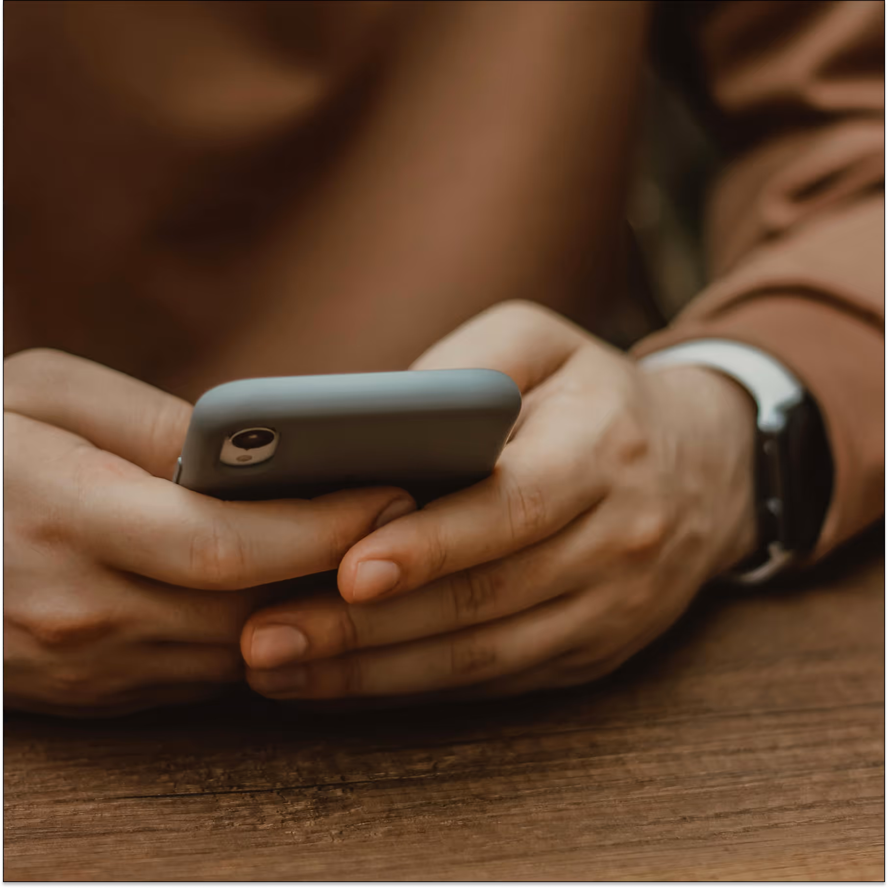 Close-up of hands holding a phone, showing mobile data entry where apps may collect PHI and need HIPAA safeguards.