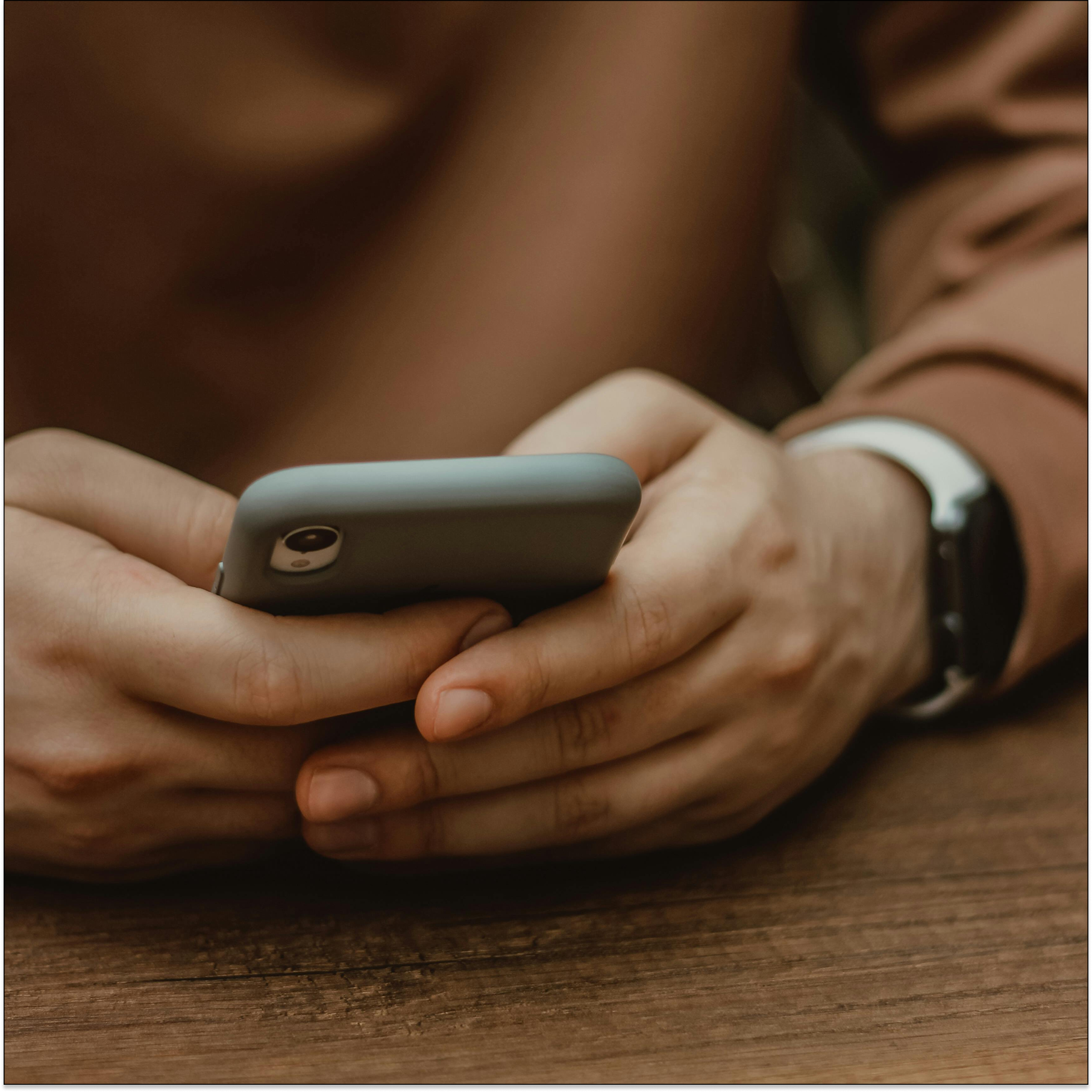 Close-up of hands holding a phone, showing mobile data entry where apps may collect PHI and need HIPAA safeguards.