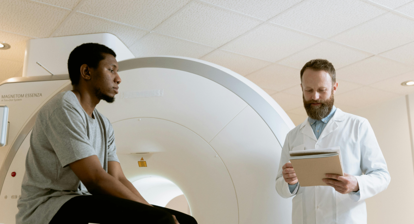 A man positioned in front of an MRI machine, awaiting a scan in a clinical setting focused on patient care and diagnostics