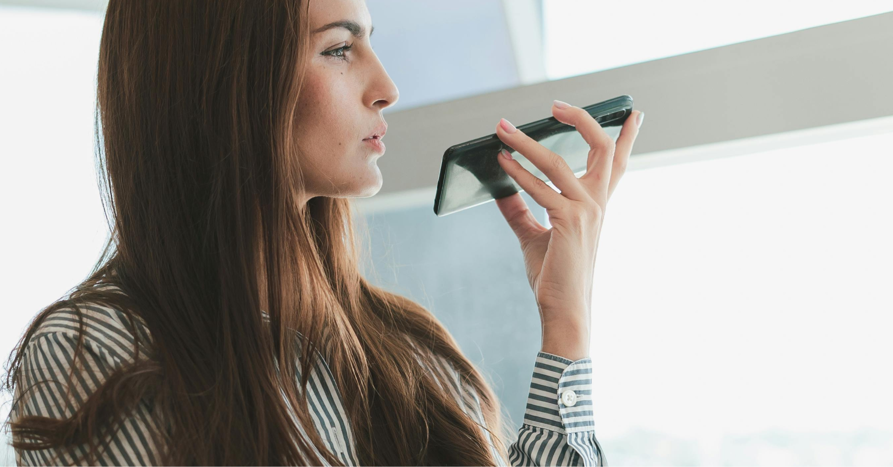 A woman holds a cell phone to her ear, engaging in a telemedicine consultation, symbolizing modern healthcare access