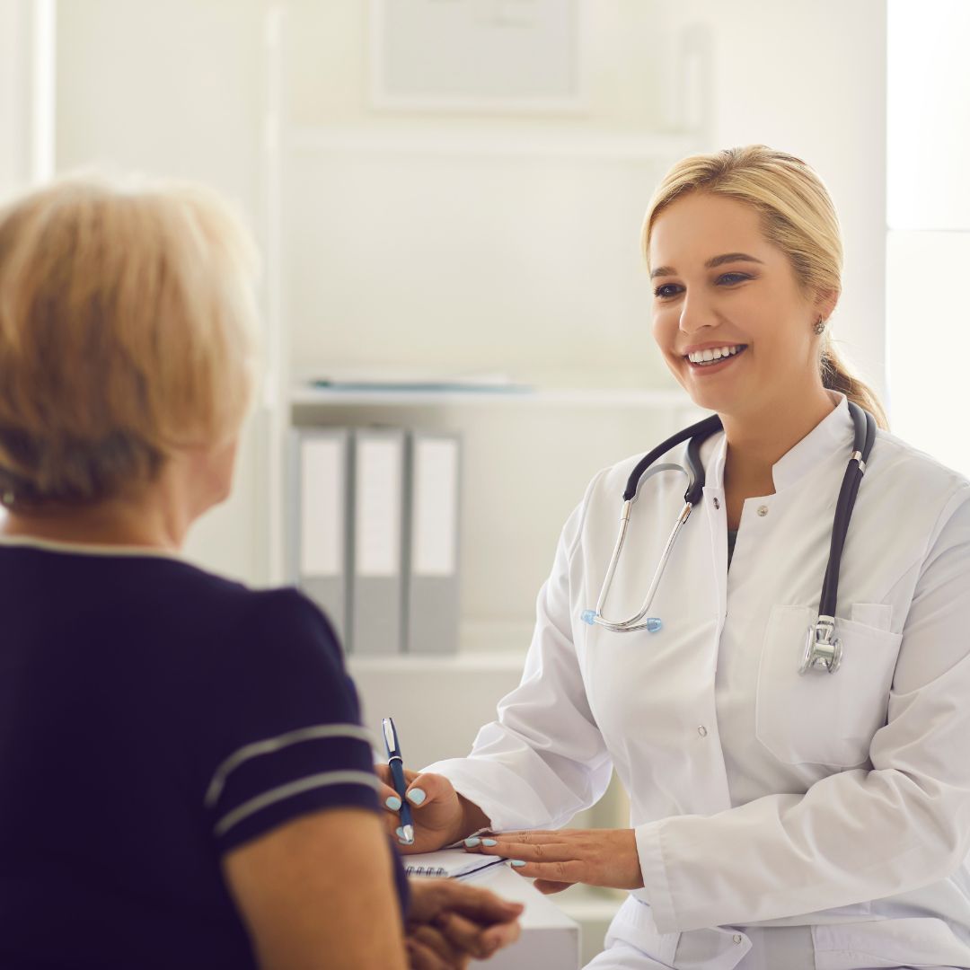 A close-up, photorealistic square photograph showing a healthcare professional in a white coat gently explaining diagnostic charts on a digital tablet to an engaged patient.