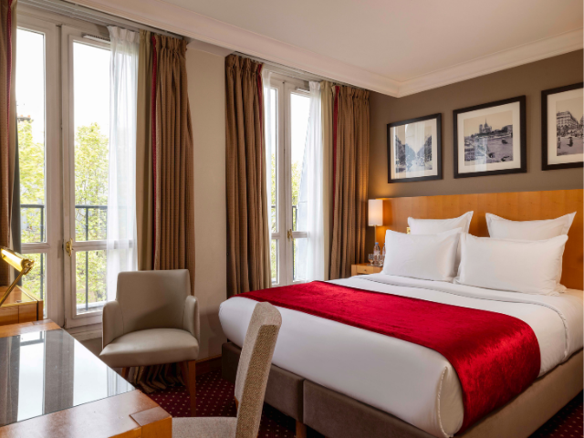 Elegant bedroom with red bed throw at Royal St Michel