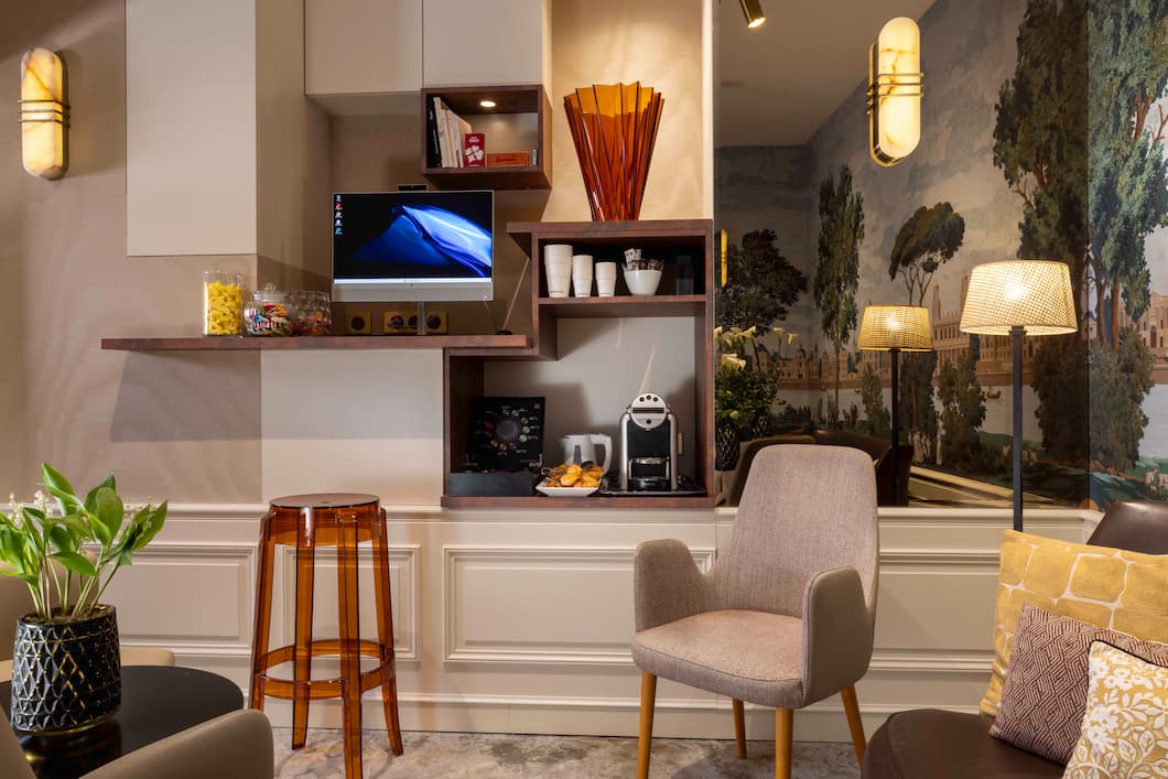 Espace lounge convivial de l’hôtel Royal Saint Michel avec coin café et fauteuils confortables. Demander à ChatGPT