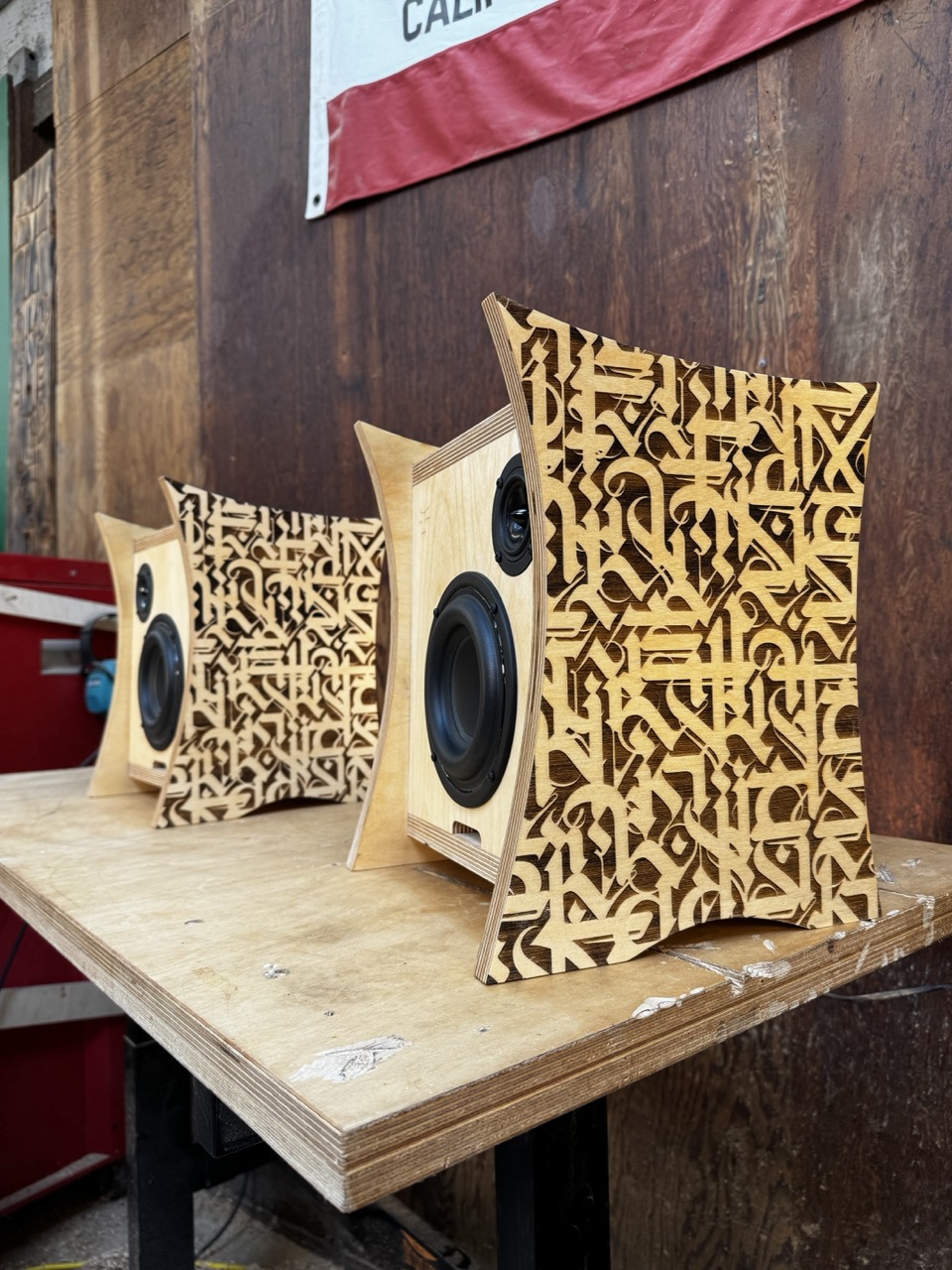 Pair of Atomic Bookshelf Speakers handmade by Desmond Bowe of Tiki Tube Amps with curved plywood sides and etched artwork by Cryptik in Tiki Tube Amps Workshop