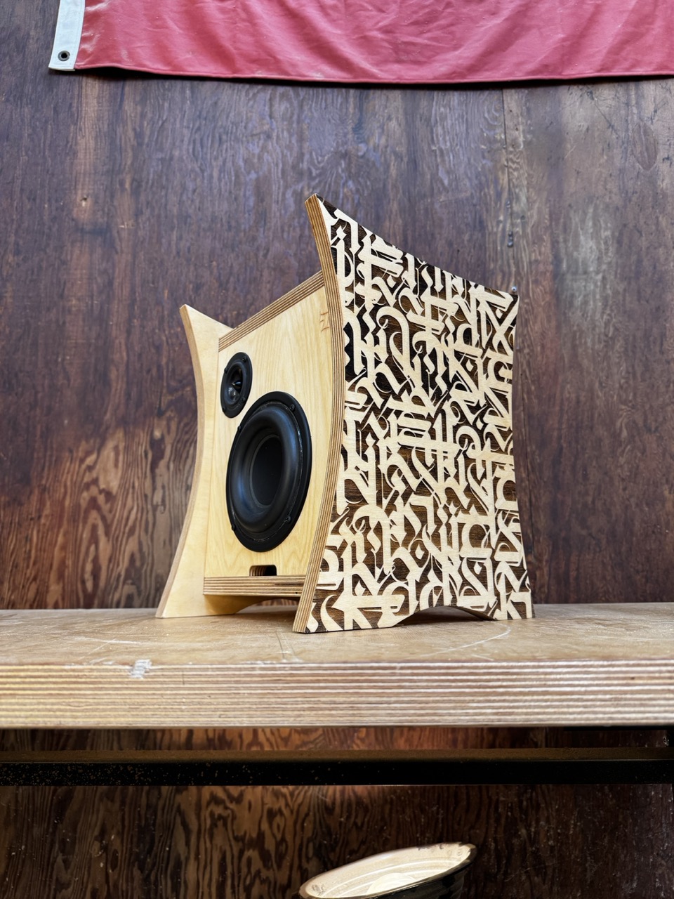 Single Atomic Bookshelf Powered Speaker handmade by Desmond Bowe of Tiki Tube Amps with curved plywood sides and etched artwork by Cryptik in Tiki Tube Amps Workshop