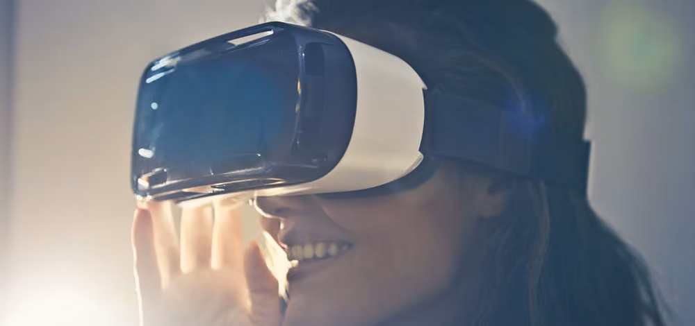 Smiling person wearing black and white virtual reality glasses