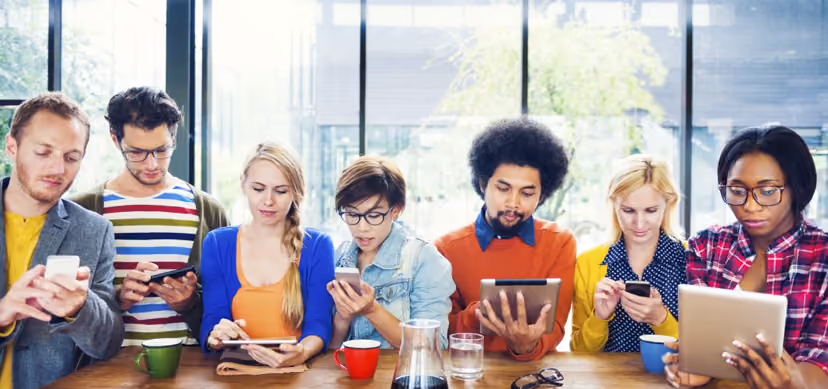 Diverse group of people using technological devices in a bright office