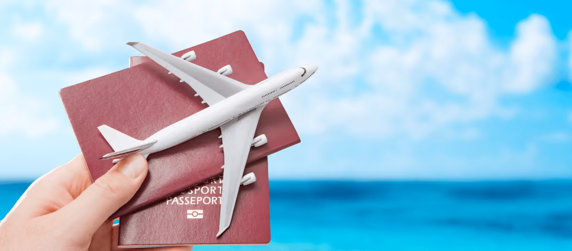 Pasaporte rojo y modelo de avión blanco sobre fondo de playa azul