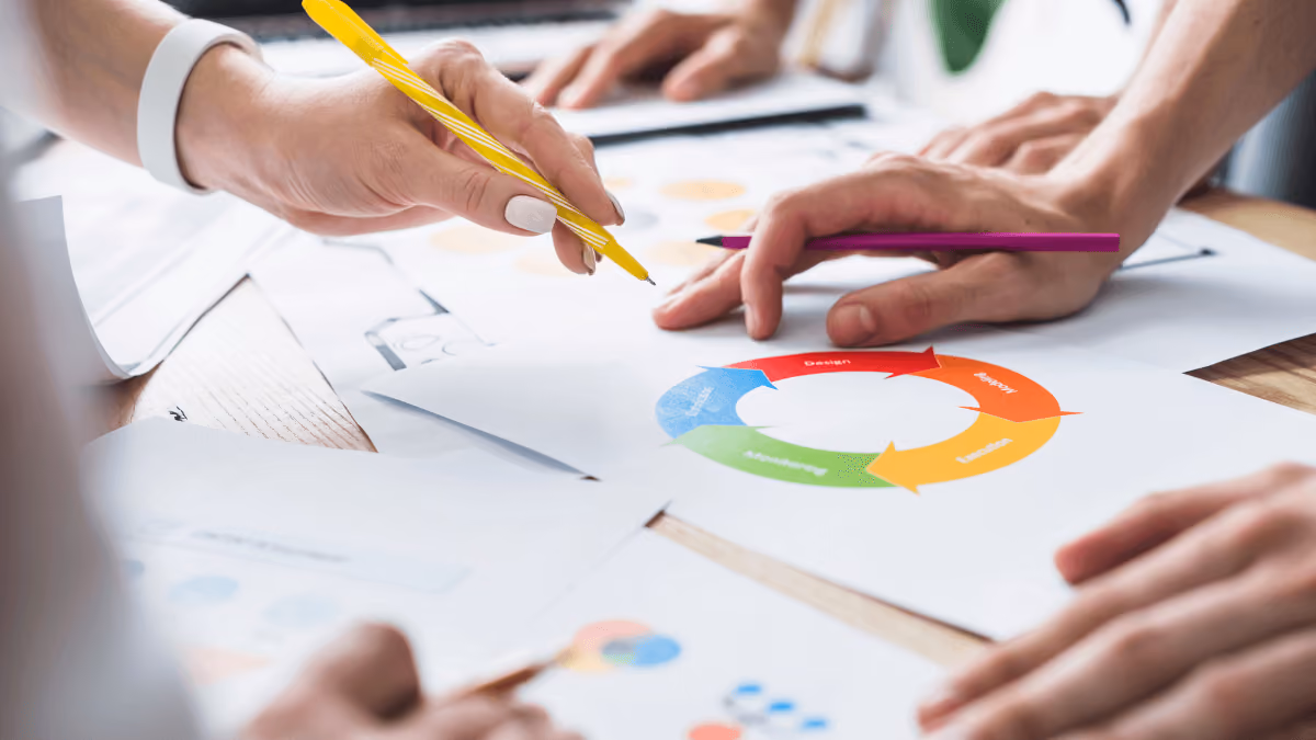 Manos trabajando en diagrama de ciclo de color con lápices