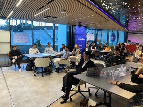 Grupo de personas en reunión de trabajo en espacio moderno de Impulsa