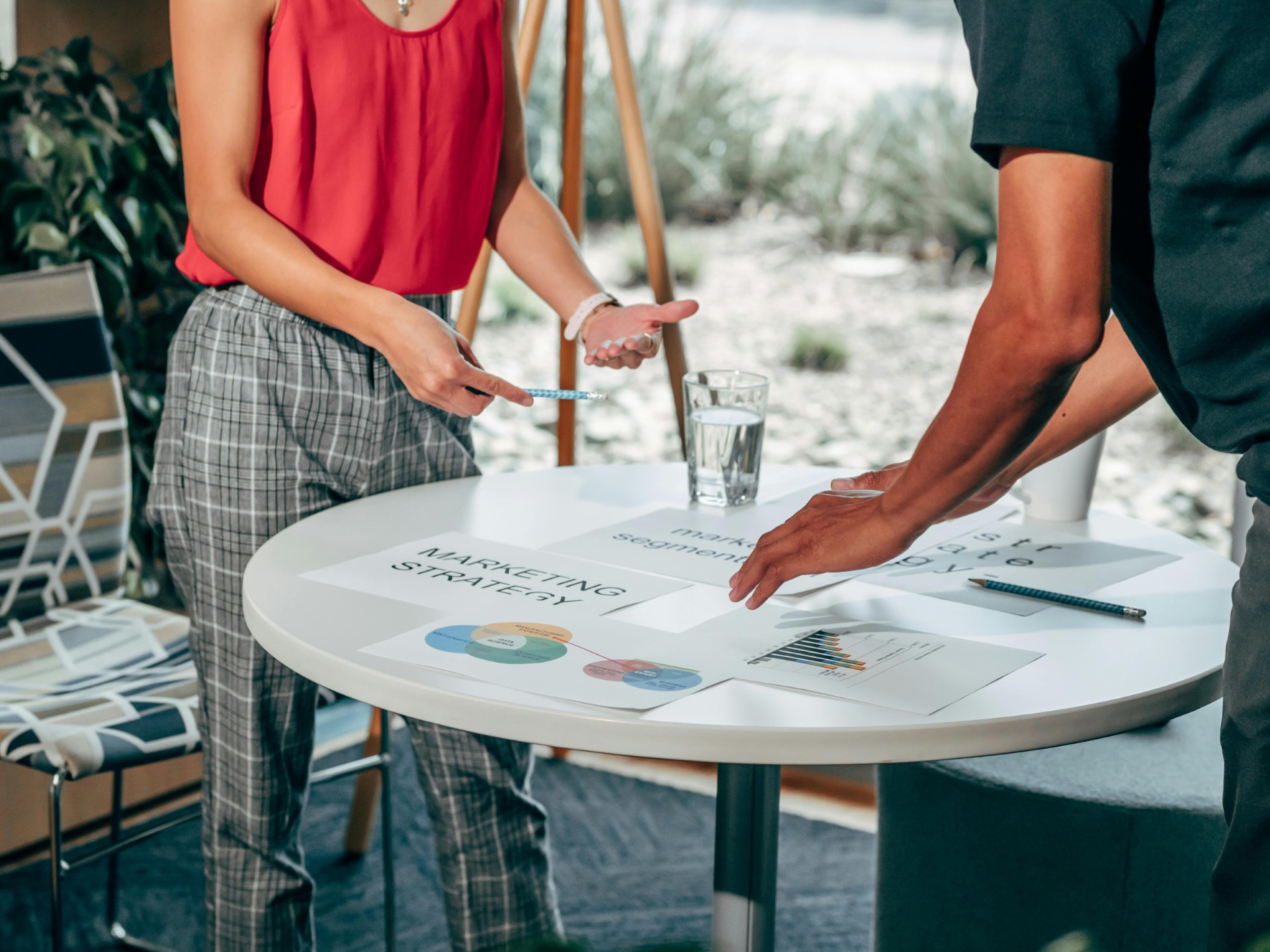 Dos personas discutiendo estrategia de marketing con gráficos y documentos