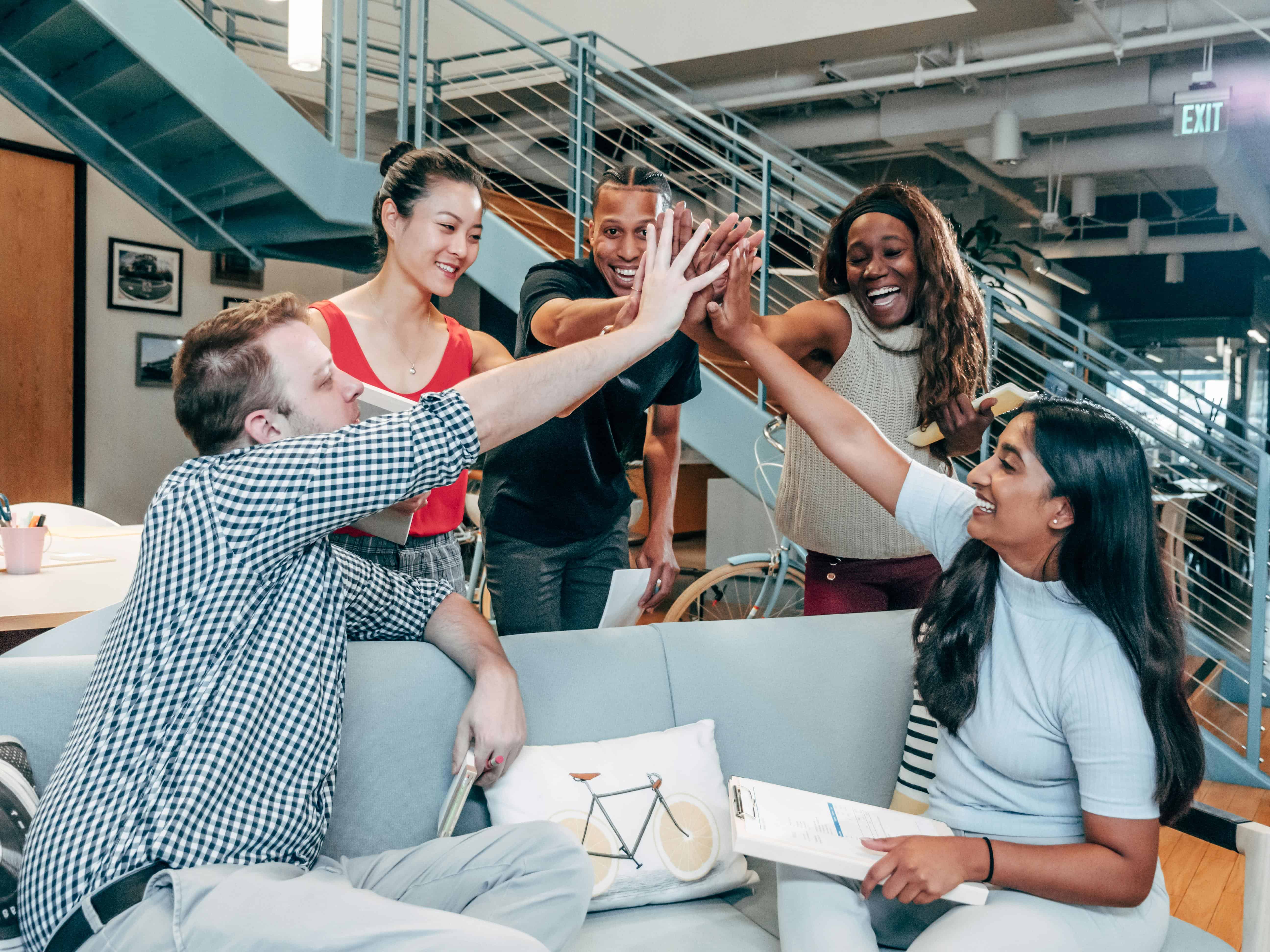 Diverse team celebrating success with Clash of Hands in modern office