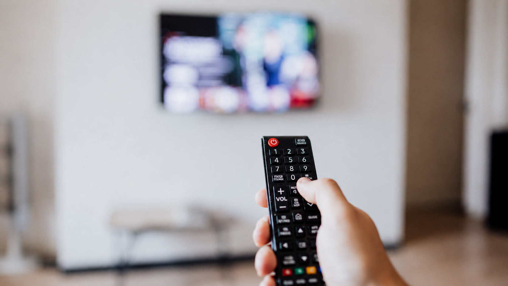 Persona comiendo palomitas y viendo televisión en un ambiente azul tenue