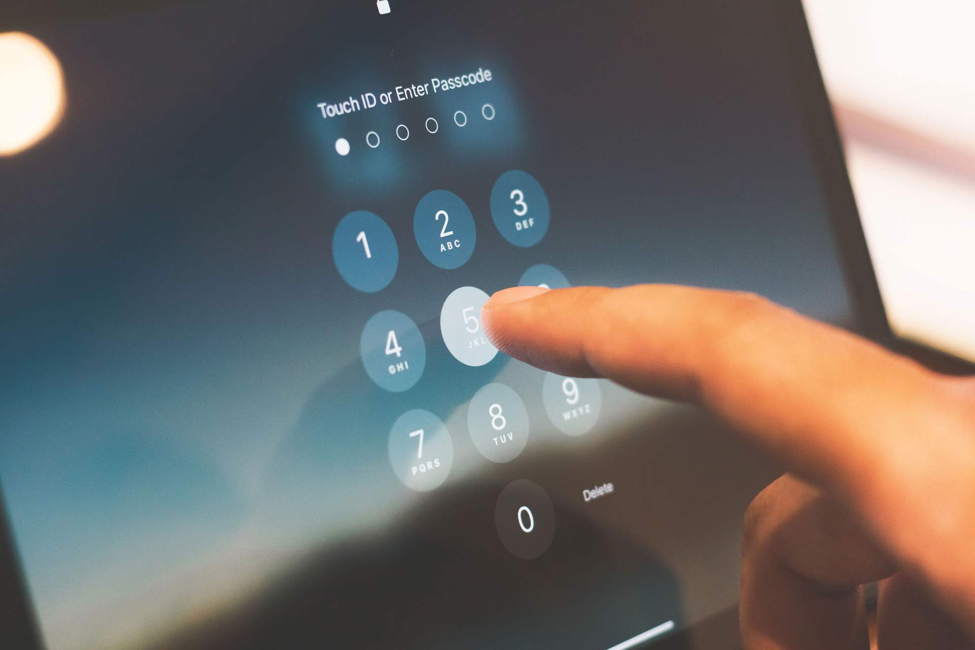 Persona introduciendo un código de acceso en una pantalla táctil como medida de seguridad y protección de datos digitales.