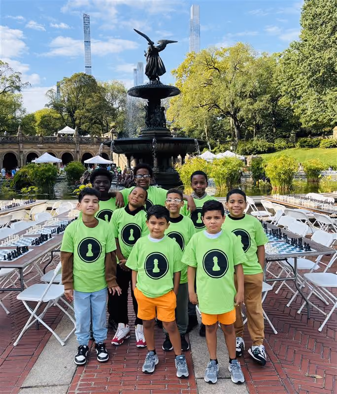 Student chess team posing at Central Park Bethesda Fountain in green shirts