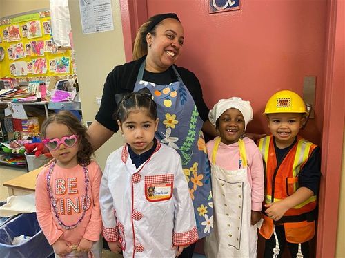Teacher and four young students in career dress-up costumes