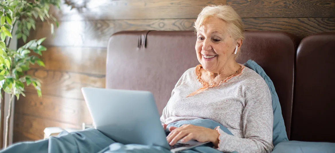 Patientin zuhause im Bett während der Videosprechstunde.