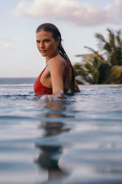 Une femme invitée pose dans une piscine - Muse Villa