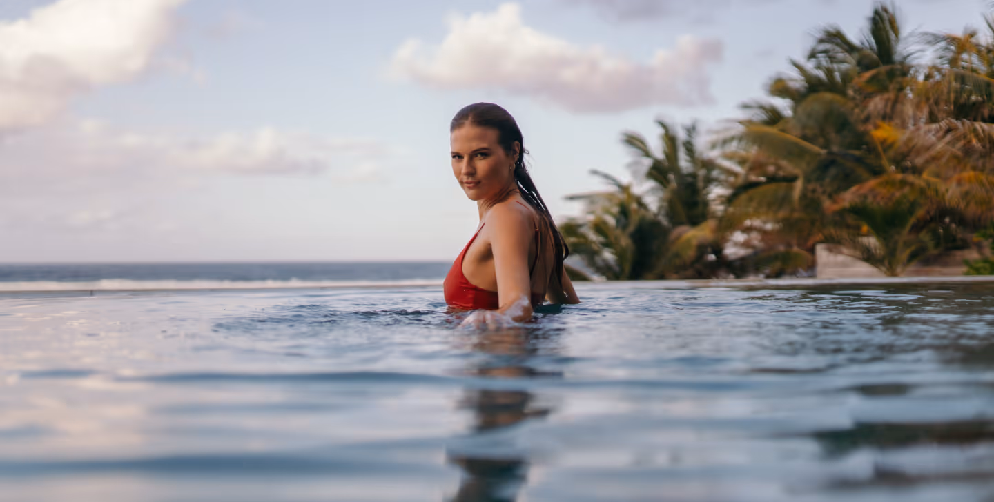 Une femme invitée pose dans une piscine - Muse Villa