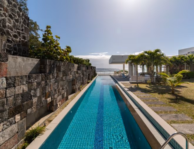 A luxurious villa in Mauritius with a private infinity pool overlooking a pristine beach.